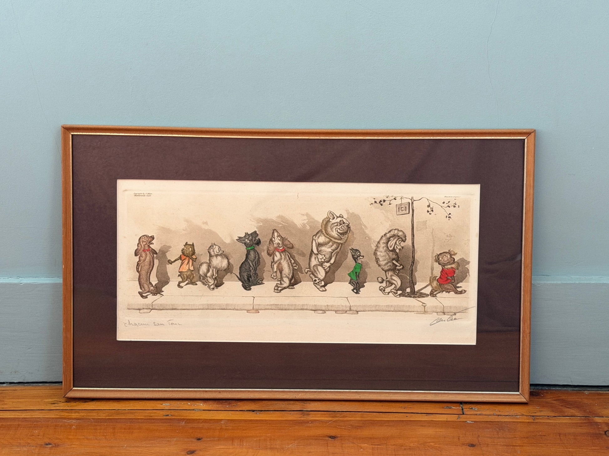 Framed illustration of cartoon dog characters on a wooden surface with a light blue wall background