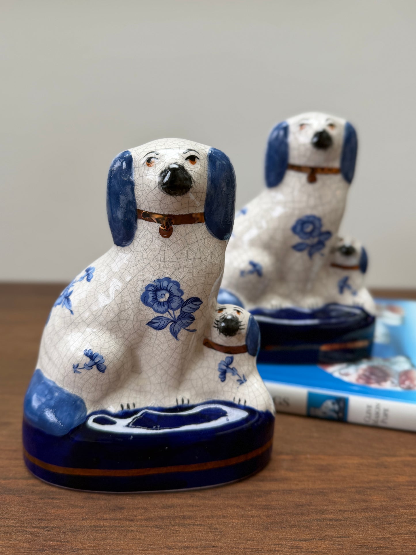 Ceramic dog figurine with blue floral patterns on a wooden surface