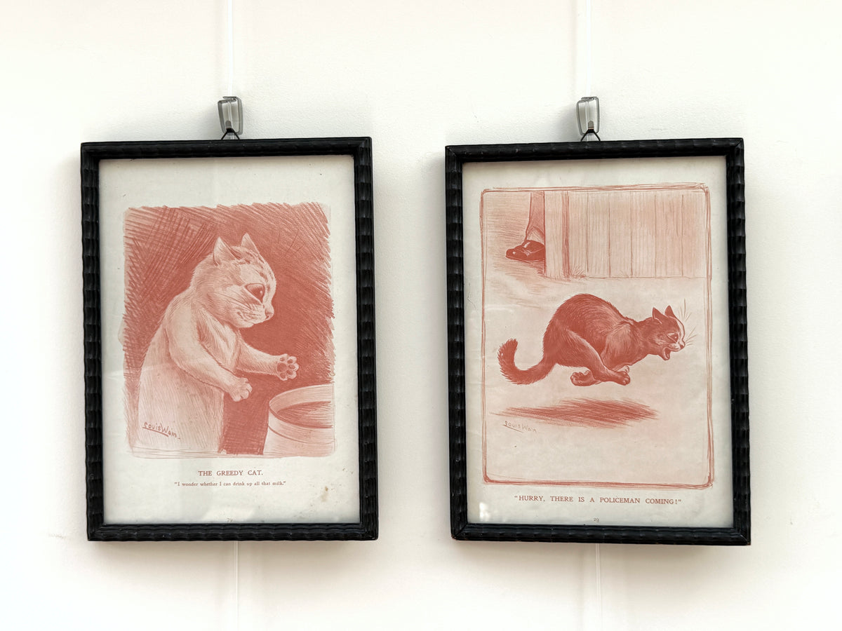 Pair of antique Louis Wain cat prints in matching black wooden frames